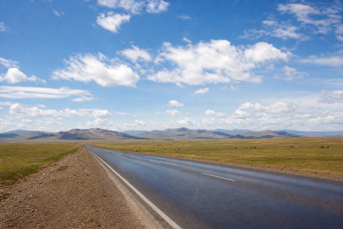 The paved road west out of Ulaanbaatar crossing open grassland on the way to Hustai National Park